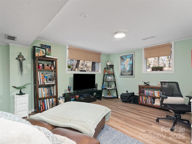 home office with a textured ceiling and light wood-type flooring