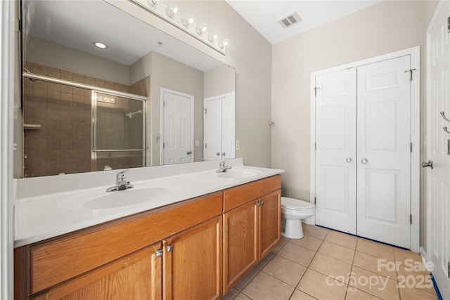 bathroom with toilet, vanity, tile patterned flooring, and walk in shower