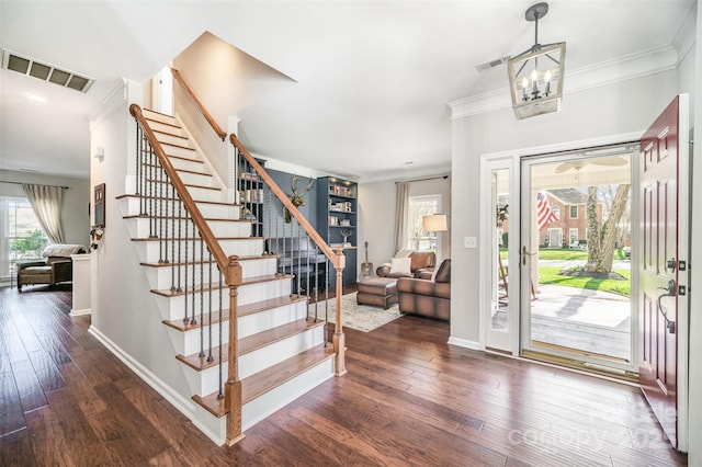 entryway with visible vents, baseboards, stairway, wood finished floors, and crown molding