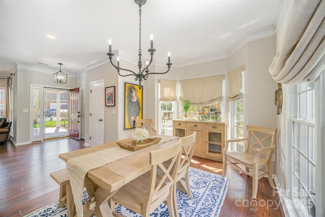 dining area with a healthy amount of sunlight, an inviting chandelier, wood-type flooring, and ornamental molding