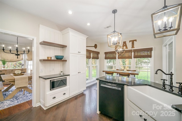 kitchen featuring a sink, visible vents, black dishwasher, stainless steel microwave, and an inviting chandelier