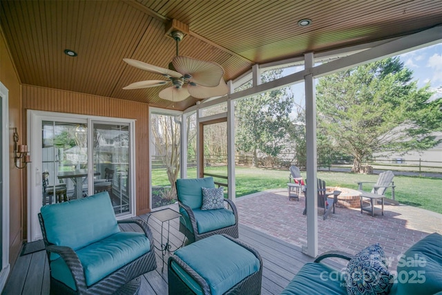 sunroom / solarium featuring a ceiling fan and wood ceiling