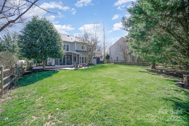 view of yard featuring a patio area, a sunroom, and a fenced backyard