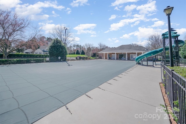 view of pool featuring playground community and fence