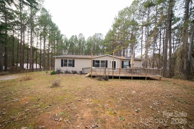 rear view of property featuring a deck and a yard