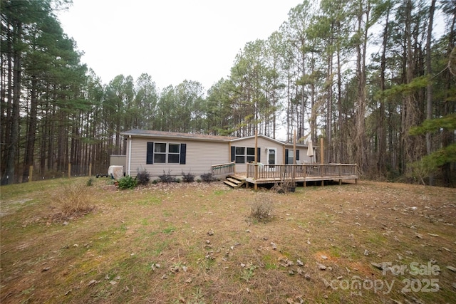 back of property featuring a wooden deck and a yard