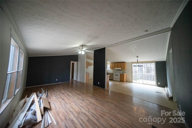 unfurnished living room featuring crown molding, vaulted ceiling, hardwood / wood-style flooring, ceiling fan with notable chandelier, and a textured ceiling