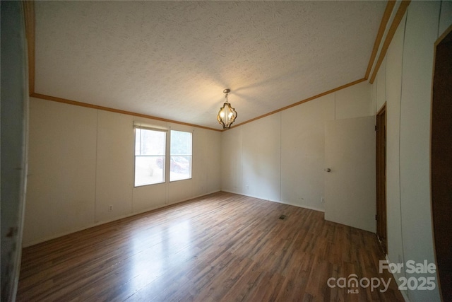 empty room with dark hardwood / wood-style floors and a textured ceiling