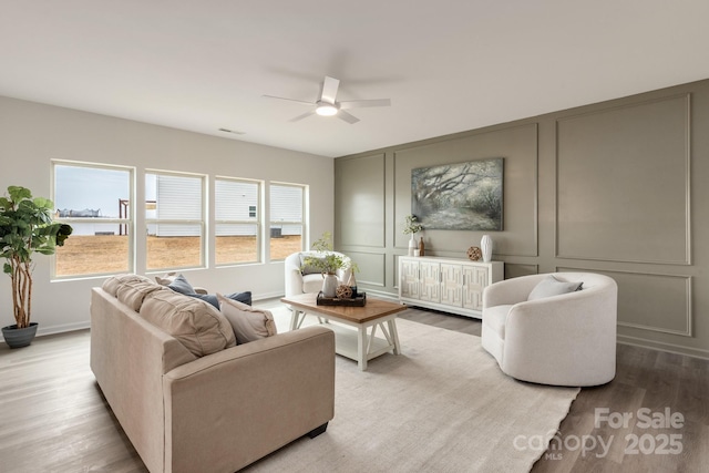 living room with light hardwood / wood-style flooring and ceiling fan