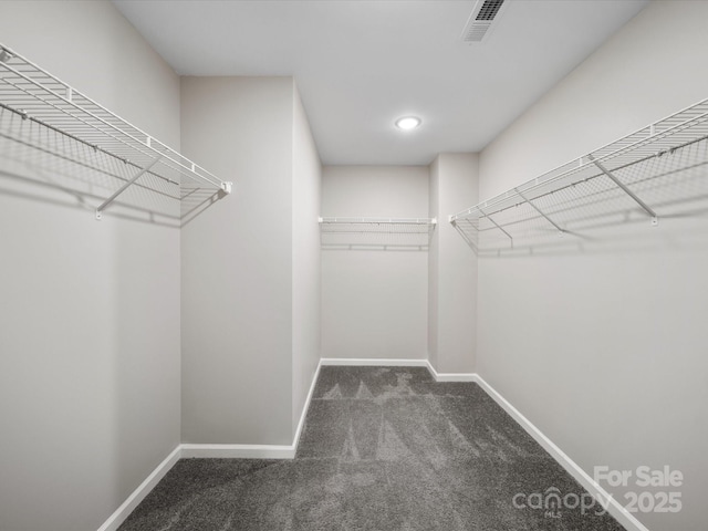 spacious closet featuring dark carpet