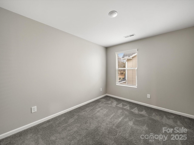 spare room featuring dark colored carpet