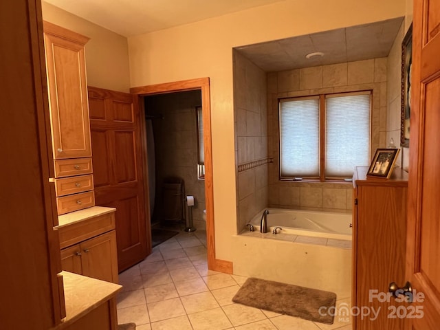 bathroom featuring tile patterned flooring, vanity, and a tub to relax in