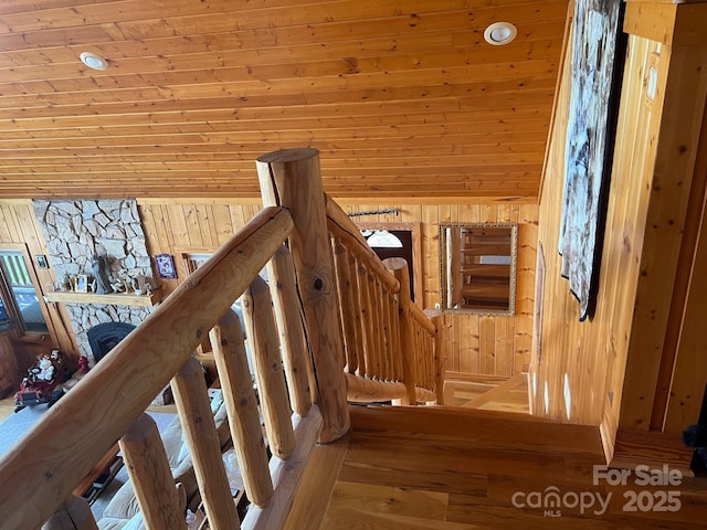 stairs featuring wooden walls and a fireplace