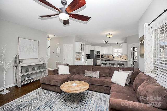 living room with dark hardwood / wood-style floors and ceiling fan