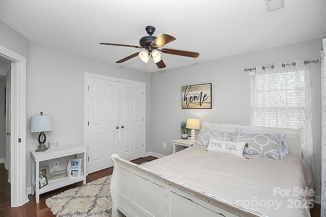 bedroom featuring ceiling fan, dark hardwood / wood-style flooring, and a closet