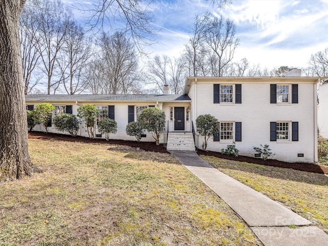 tri-level home with a front lawn, brick siding, and crawl space