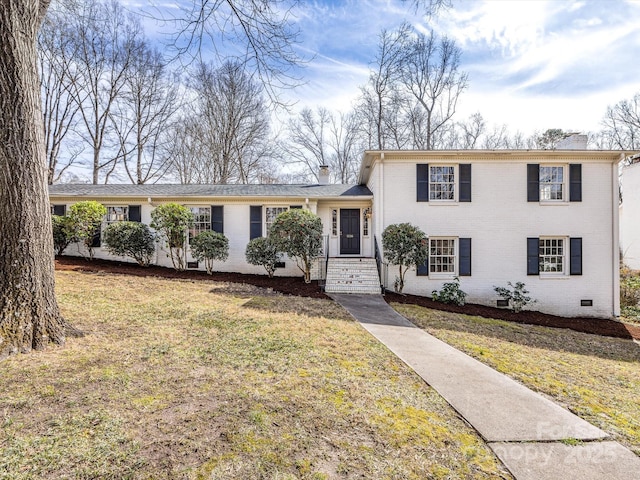 tri-level home with a front yard, crawl space, brick siding, and a chimney