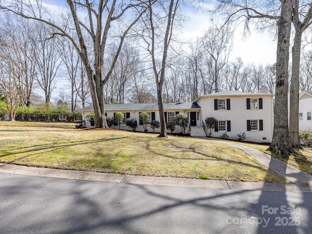 tri-level home with crawl space, stucco siding, a chimney, and a front yard