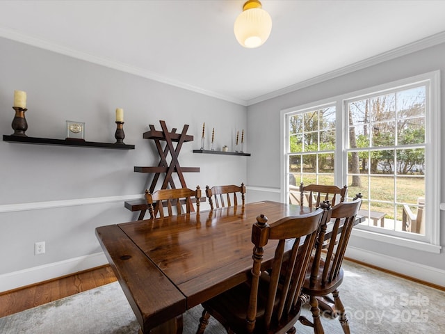 dining room featuring ornamental molding, wood finished floors, and baseboards