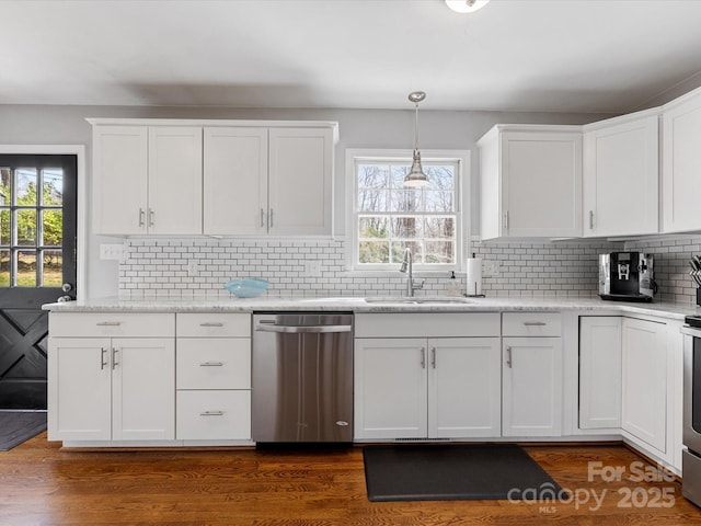 kitchen featuring white cabinetry, decorative light fixtures, and stainless steel dishwasher