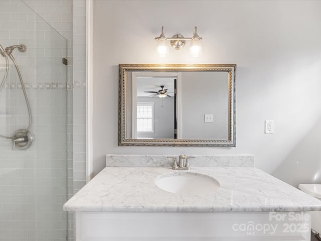 full bathroom featuring a tile shower, vanity, and toilet