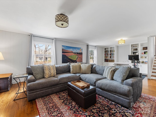 living area featuring stairs, built in features, and wood finished floors