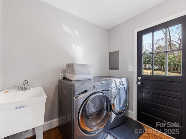 clothes washing area featuring laundry area, electric panel, dark wood-style floors, independent washer and dryer, and a sink