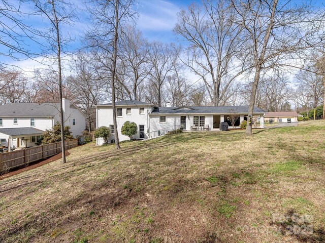 rear view of property with a yard and fence