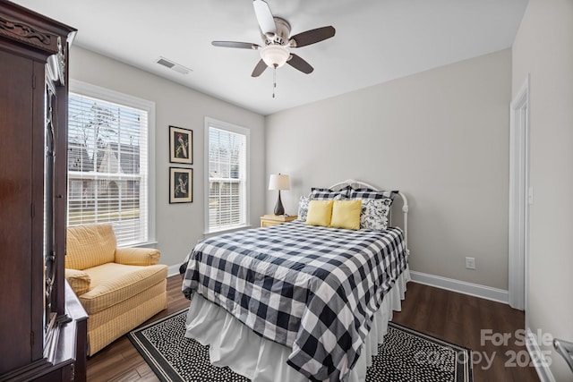 bedroom with dark wood-style floors, a ceiling fan, visible vents, and baseboards