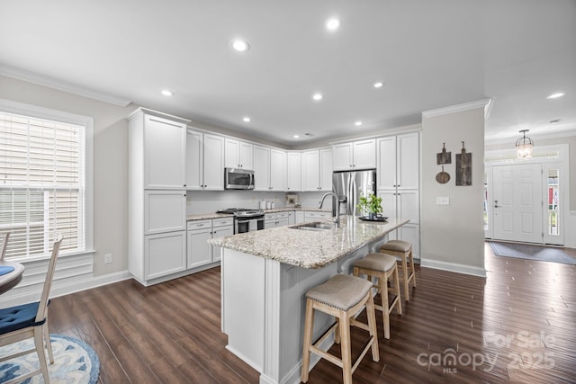 kitchen featuring appliances with stainless steel finishes, white cabinets, and a sink