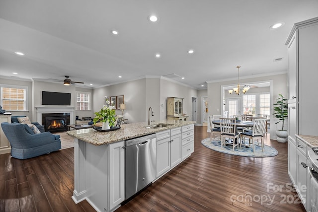 kitchen with dishwasher, open floor plan, a kitchen island with sink, pendant lighting, and a sink