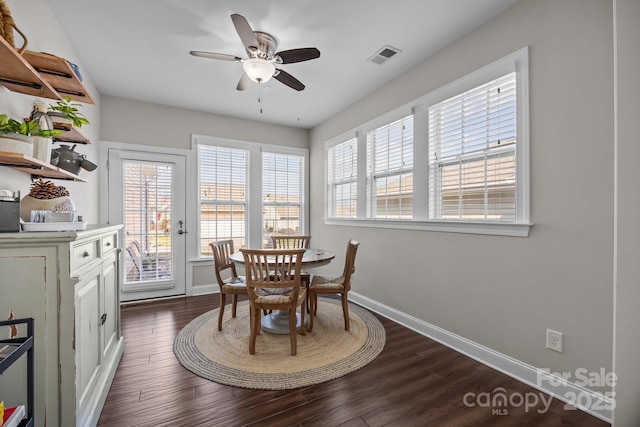 dining space featuring dark wood-style floors, ceiling fan, visible vents, and baseboards