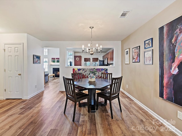 dining area featuring an inviting chandelier and light hardwood / wood-style floors