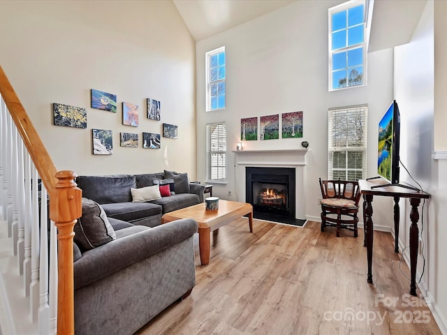 living room with a towering ceiling and light hardwood / wood-style floors