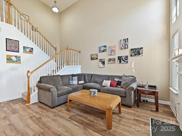 living room with a high ceiling and light wood-type flooring