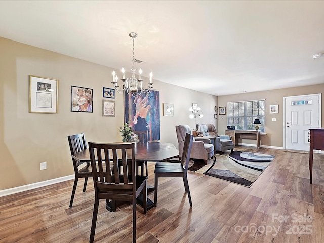 dining area featuring hardwood / wood-style flooring and an inviting chandelier