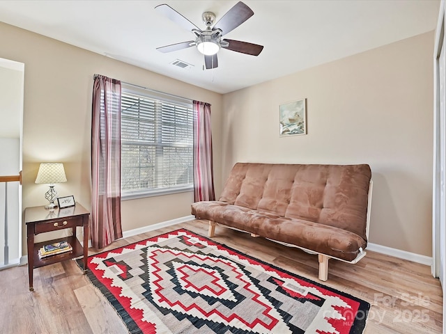 living area featuring light hardwood / wood-style flooring and ceiling fan