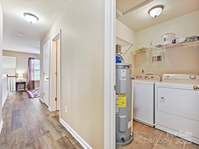 laundry area with water heater, washer and dryer, and hardwood / wood-style floors