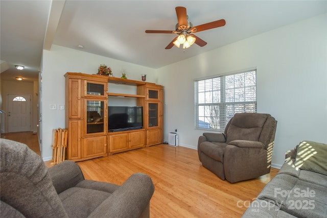 living room with ceiling fan, light wood-style flooring, and baseboards