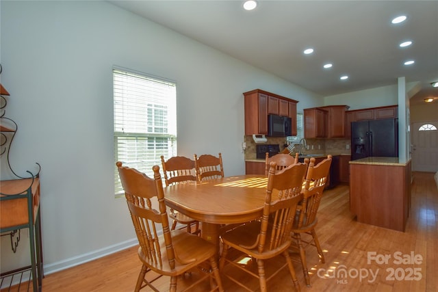 dining room with baseboards, light wood-type flooring, and recessed lighting