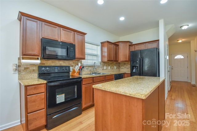 kitchen featuring black appliances, backsplash, a sink, and a center island