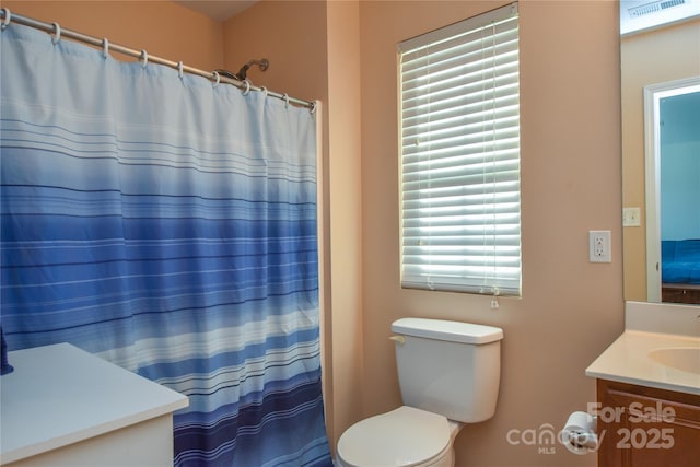 bathroom featuring a shower with shower curtain, visible vents, vanity, and toilet