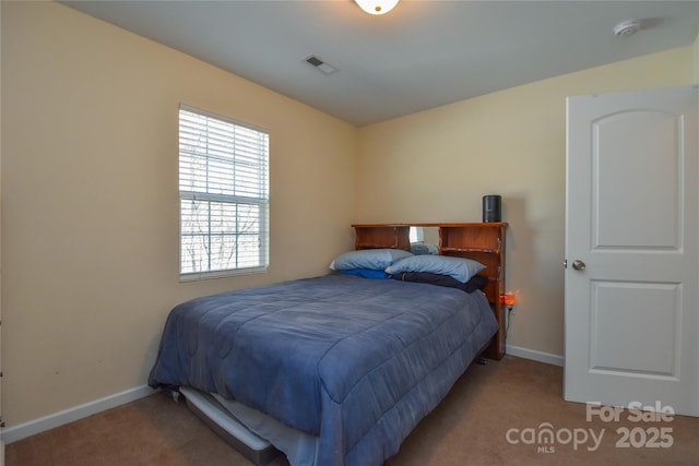 carpeted bedroom with visible vents and baseboards