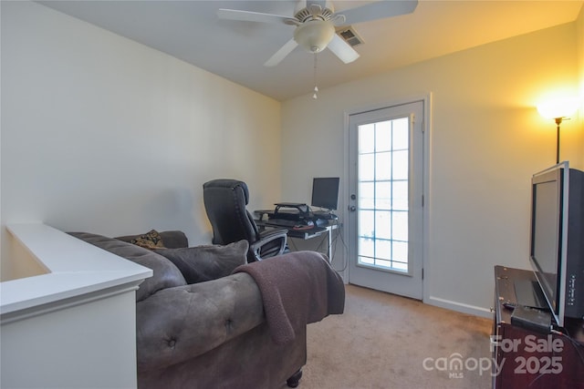 office featuring baseboards, a ceiling fan, visible vents, and light colored carpet