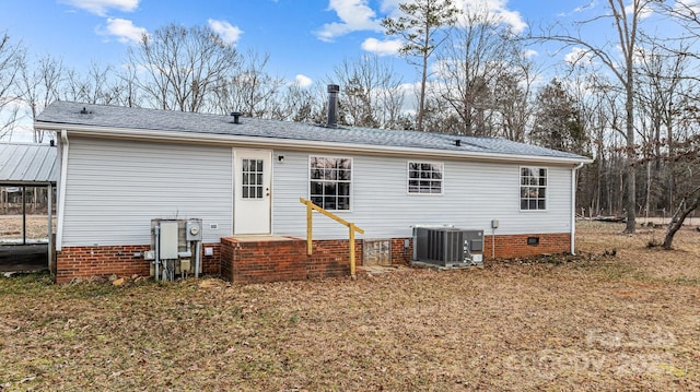 rear view of property featuring central AC unit and a lawn