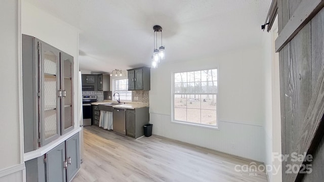 kitchen with sink, decorative light fixtures, plenty of natural light, stainless steel appliances, and backsplash