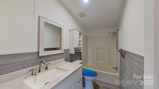 full bathroom featuring washtub / shower combination, vanity, and toilet