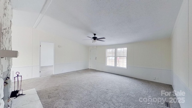 spare room featuring ceiling fan, carpet, and a textured ceiling