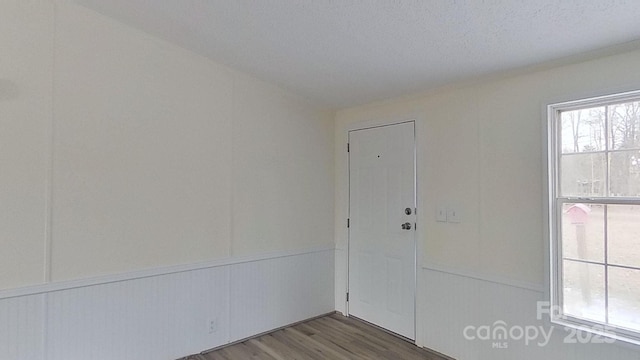 unfurnished room with wood-type flooring and a textured ceiling