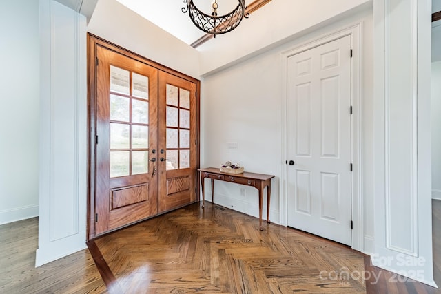 entryway with dark parquet flooring and french doors